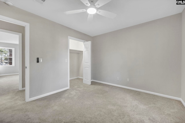 unfurnished bedroom featuring a closet, ceiling fan, and light colored carpet