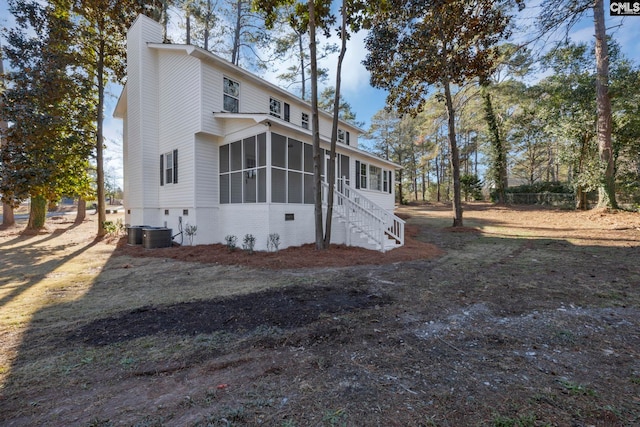 view of side of home featuring central air condition unit and a sunroom