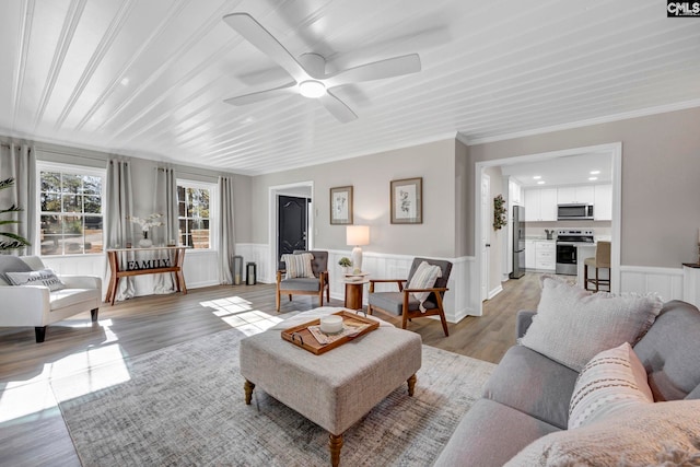 living room with ceiling fan, light hardwood / wood-style floors, and ornamental molding