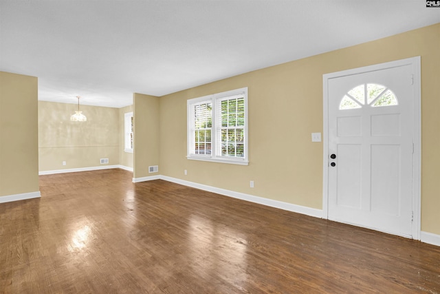 foyer featuring dark hardwood / wood-style floors and an inviting chandelier