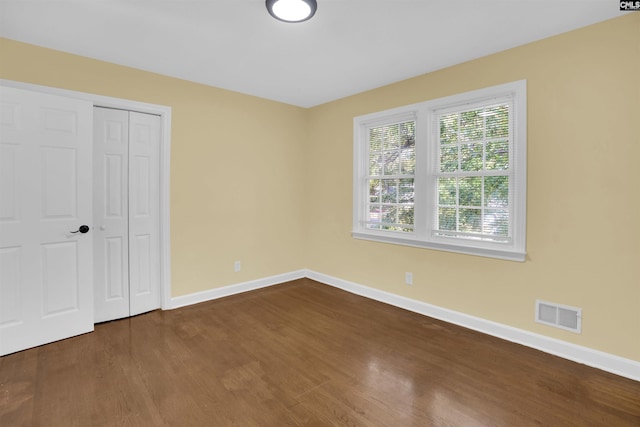 unfurnished bedroom with wood-type flooring and a closet