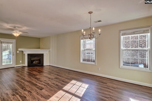 unfurnished living room with dark wood-type flooring and ceiling fan with notable chandelier