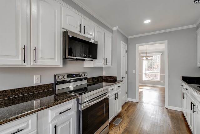 kitchen with pendant lighting, dark stone countertops, white cabinetry, and stainless steel appliances