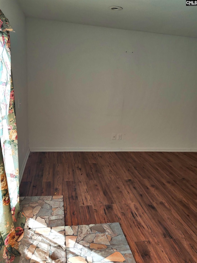 spare room featuring dark wood-type flooring