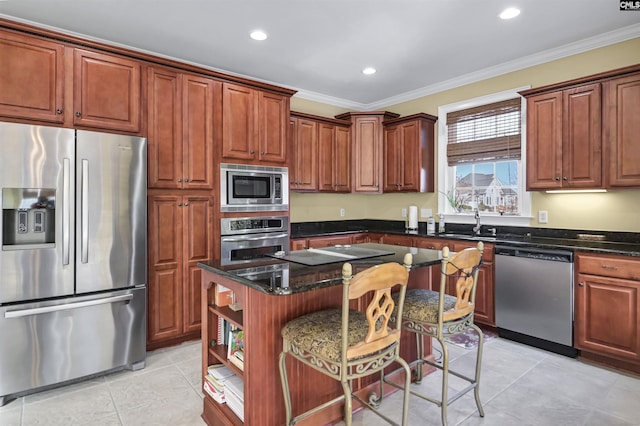 kitchen featuring a center island, a kitchen breakfast bar, dark stone countertops, ornamental molding, and stainless steel appliances