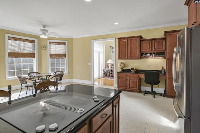 kitchen featuring crown molding, ceiling fan, stainless steel fridge, built in desk, and stovetop