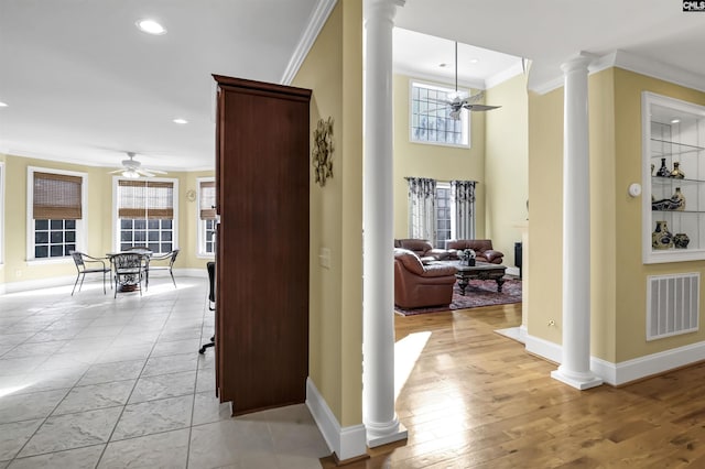 hallway with ornate columns, light hardwood / wood-style flooring, and ornamental molding