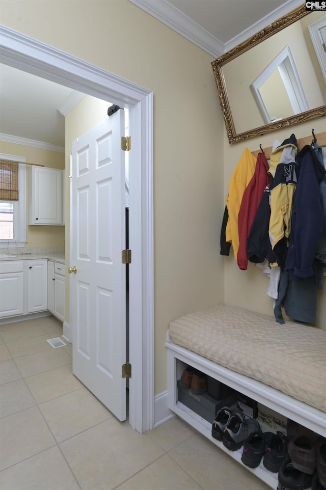 mudroom featuring crown molding and light tile patterned floors