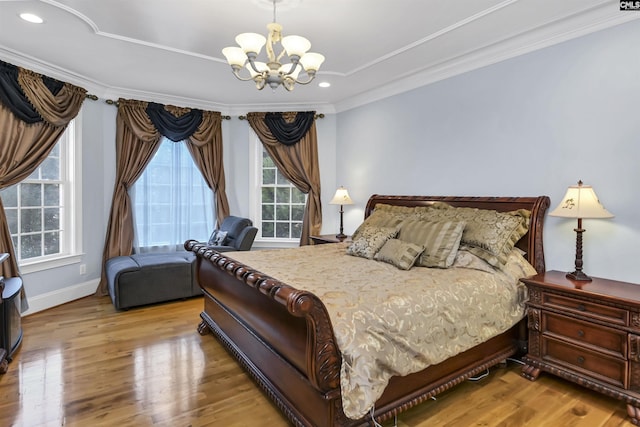 bedroom featuring hardwood / wood-style flooring, ornamental molding, and an inviting chandelier