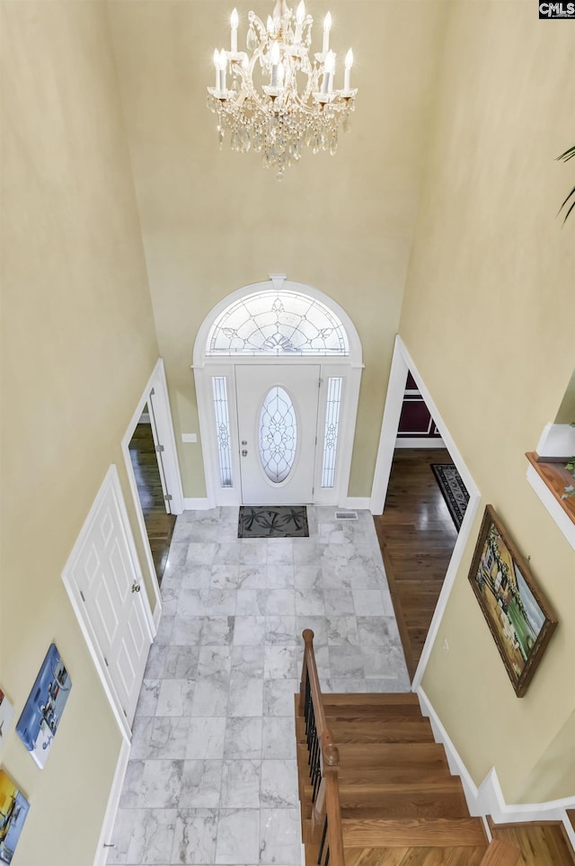 foyer entrance with a notable chandelier and a high ceiling