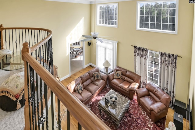 living room featuring ceiling fan, crown molding, and a high ceiling