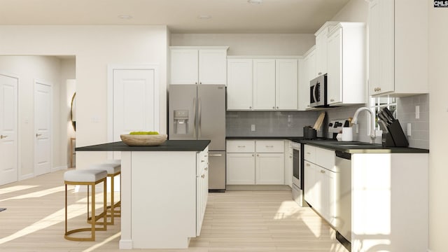 kitchen featuring a breakfast bar area, white cabinets, a kitchen island, and stainless steel appliances