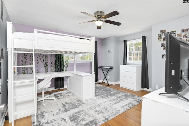 bedroom featuring multiple windows, ceiling fan, and light hardwood / wood-style flooring