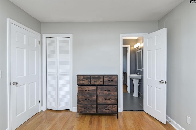 bedroom featuring connected bathroom, a closet, and light hardwood / wood-style flooring