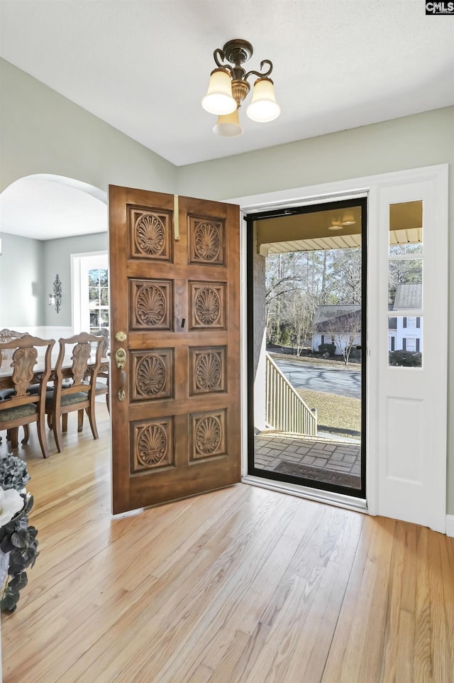 foyer with an inviting chandelier and light wood-type flooring