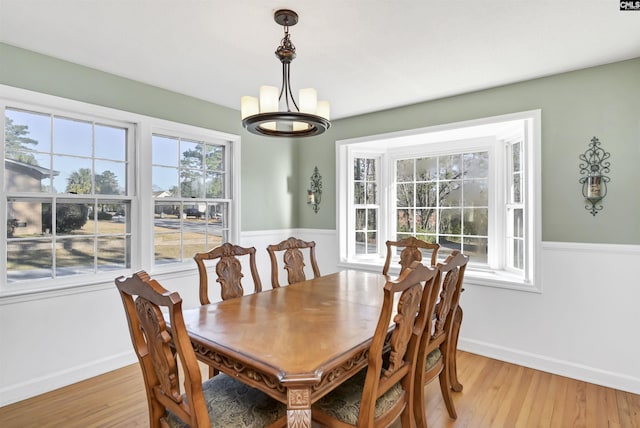 dining space featuring light hardwood / wood-style floors and a notable chandelier