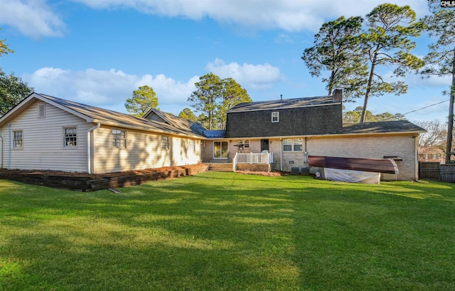 rear view of property featuring a lawn