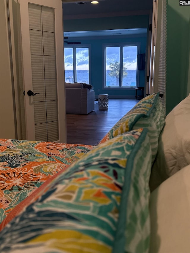 bedroom with dark hardwood / wood-style floors and a closet