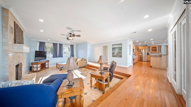 living room featuring ceiling fan, ornamental molding, and a fireplace