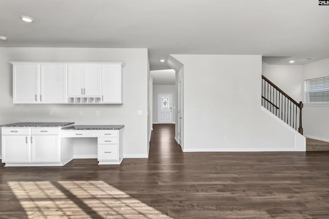 kitchen with dark stone countertops, white cabinetry, and dark wood-type flooring