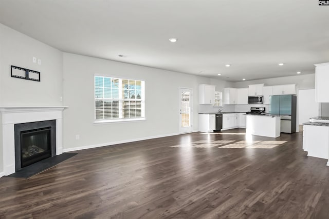 unfurnished living room with dark wood-type flooring