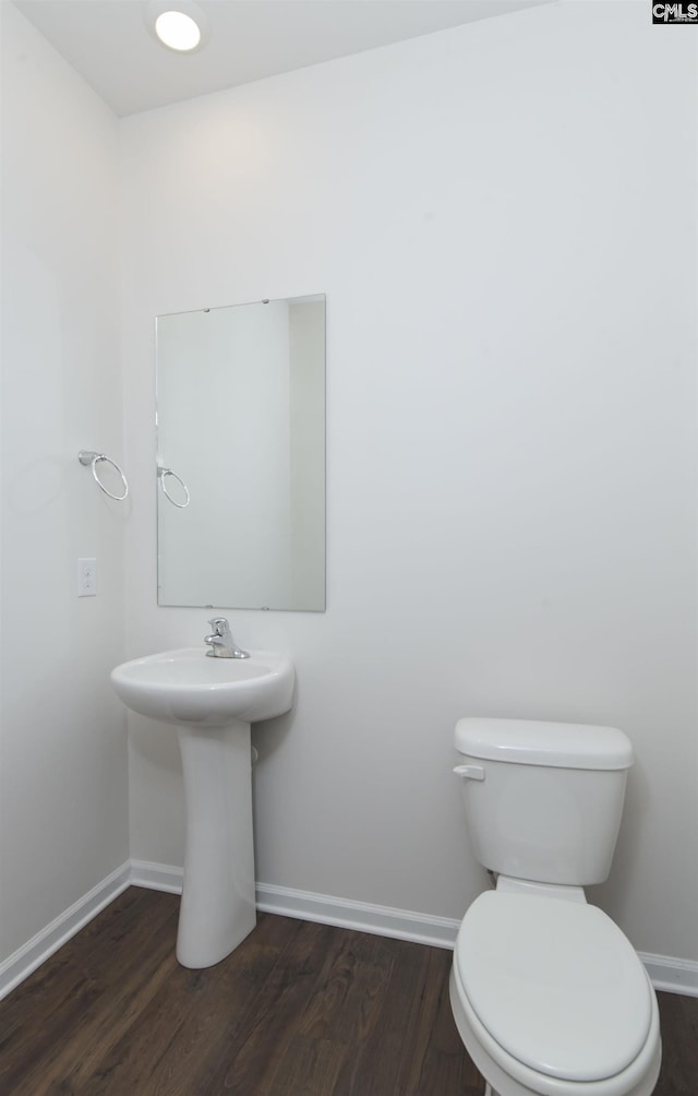 bathroom with hardwood / wood-style floors, toilet, and sink