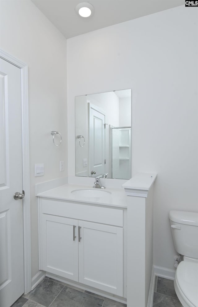 bathroom with a shower with door, vanity, and toilet