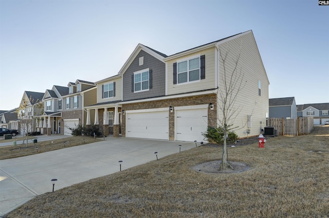 view of front of home featuring a front lawn, a garage, and central AC