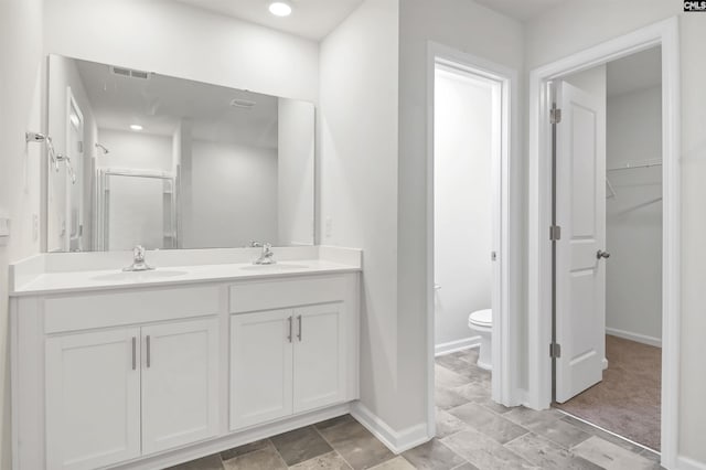 bathroom featuring vanity, toilet, and walk in shower