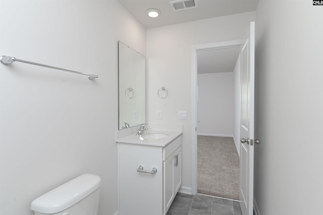 bathroom with tile patterned flooring, vanity, and toilet