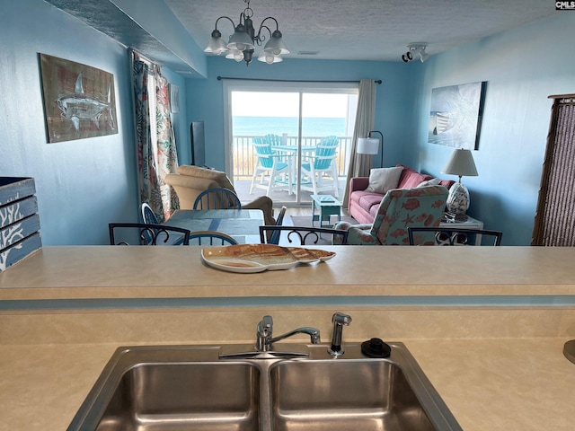 kitchen featuring sink, a chandelier, and a textured ceiling