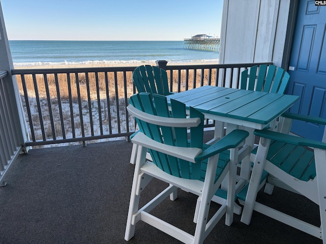 balcony featuring a view of the beach and a water view