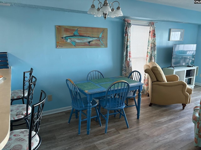 dining room with hardwood / wood-style floors and a notable chandelier