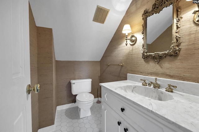 bathroom featuring tile patterned floors, vanity, vaulted ceiling, and toilet