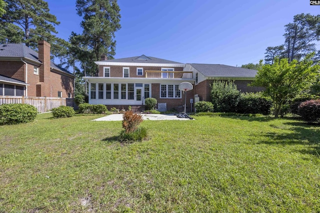 back of property featuring a lawn and a sunroom