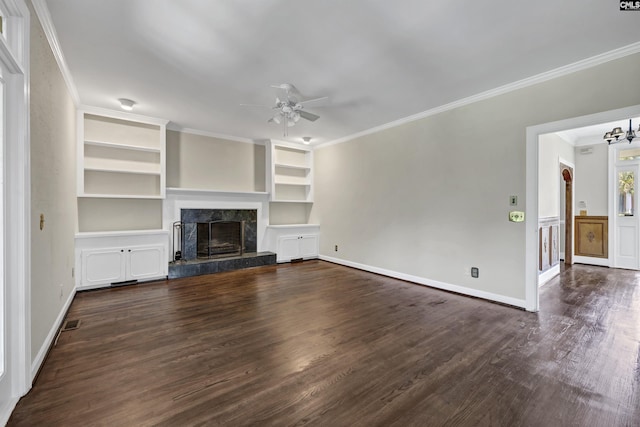 unfurnished living room featuring a high end fireplace, built in shelves, ceiling fan, dark hardwood / wood-style floors, and ornamental molding