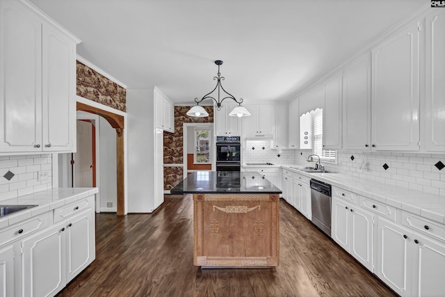 kitchen featuring white cabinets, a center island, stainless steel dishwasher, and sink