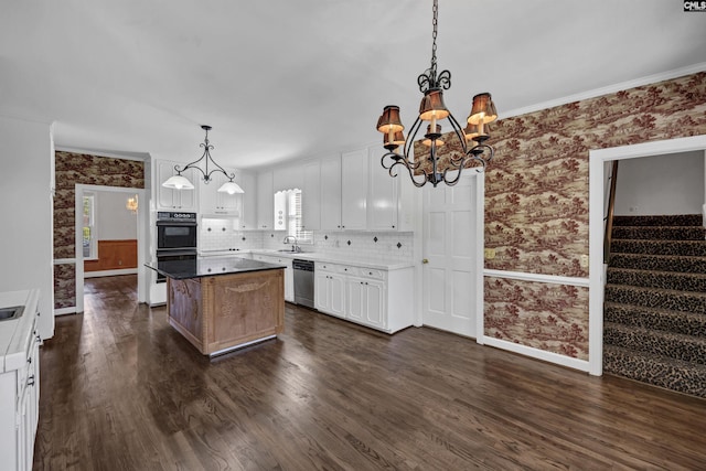 kitchen featuring decorative backsplash, stainless steel dishwasher, decorative light fixtures, white cabinets, and a center island