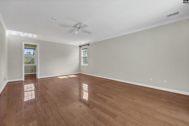 empty room featuring hardwood / wood-style flooring, a healthy amount of sunlight, and crown molding