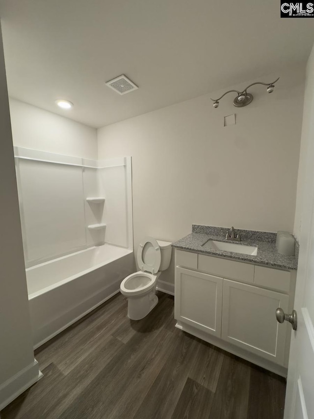 full bathroom with toilet, vanity, hardwood / wood-style flooring, and bathing tub / shower combination