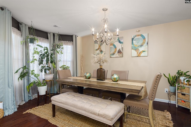 dining space with dark wood-type flooring and an inviting chandelier