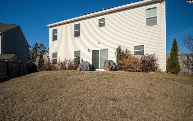 rear view of property featuring a lawn