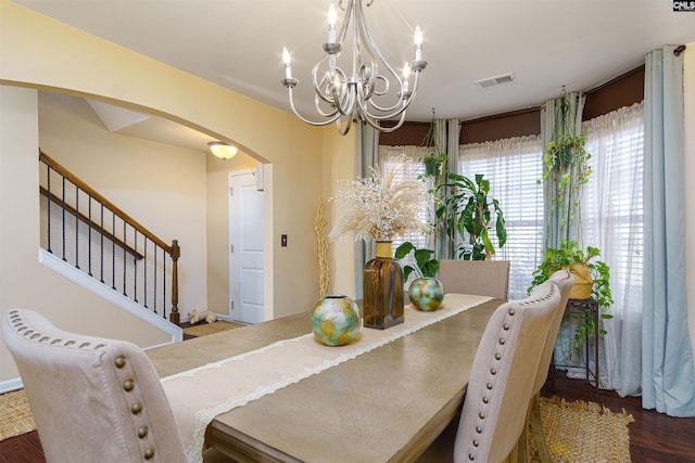 dining area with dark hardwood / wood-style flooring and a notable chandelier