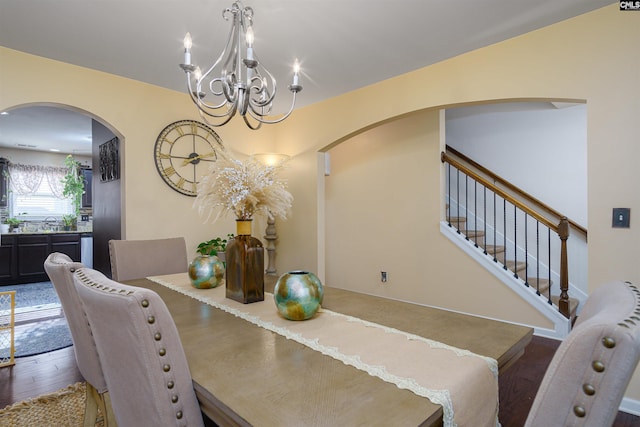 dining area featuring dark wood-type flooring and a notable chandelier