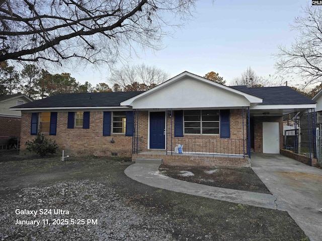 ranch-style home featuring a porch and a carport