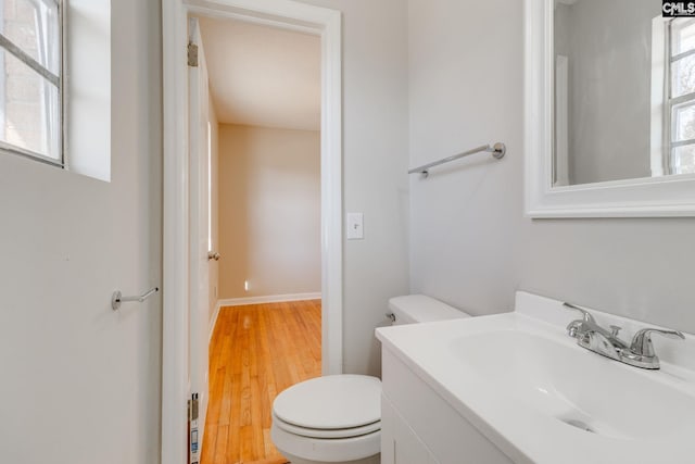 bathroom featuring toilet, hardwood / wood-style flooring, and vanity