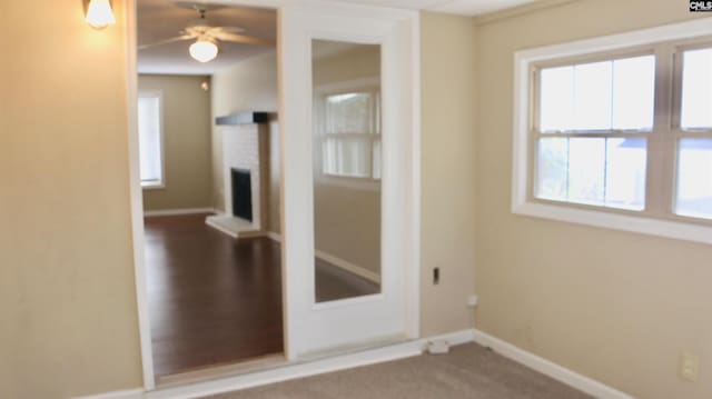 empty room with a brick fireplace and baseboards