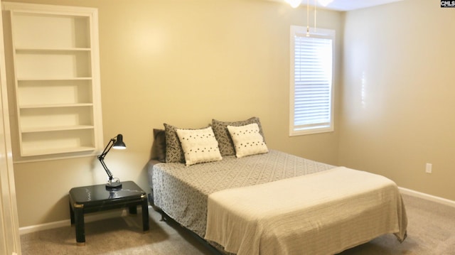 bedroom with carpet, multiple windows, and baseboards