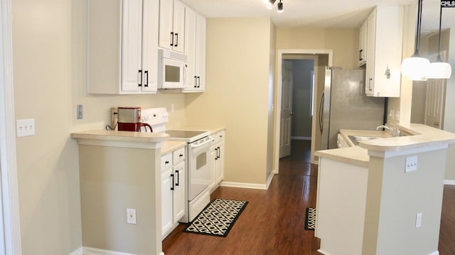 kitchen with white appliances, dark wood-style floors, light countertops, white cabinetry, and a sink