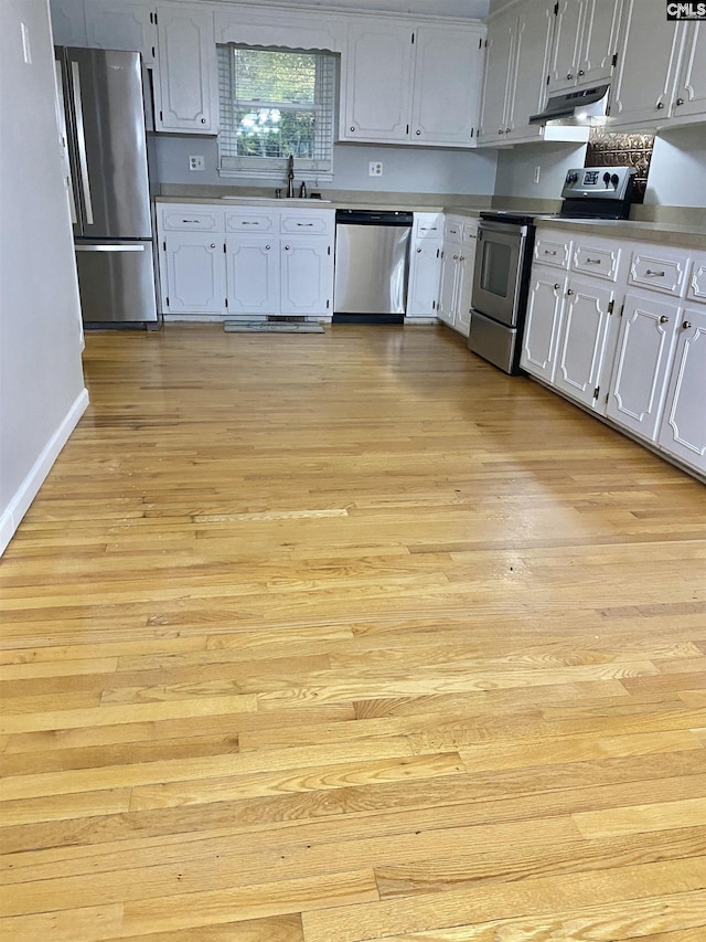 kitchen with sink, stainless steel appliances, and light hardwood / wood-style flooring